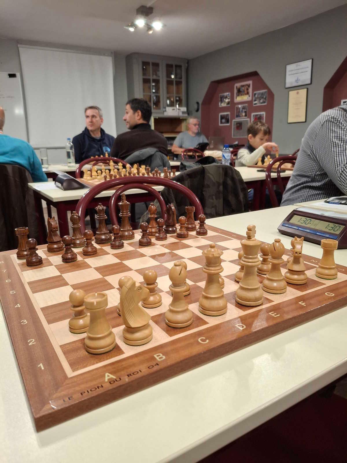 Échiquier et horloge au Cercle Le Pion du Roi Joueurs d'échecs au Cercle Le Pion du Roi